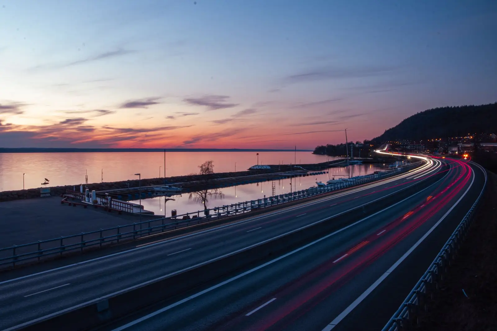 Autocesta uz obalu u sumrak, tragovi svjetala vozila